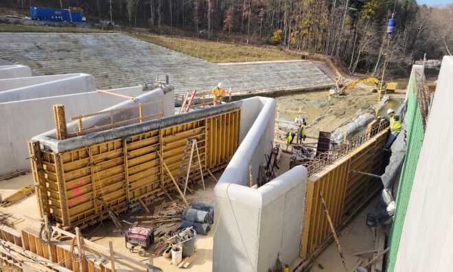 Construction workers building the Lake Williams Dam labyrinth cycle wall.