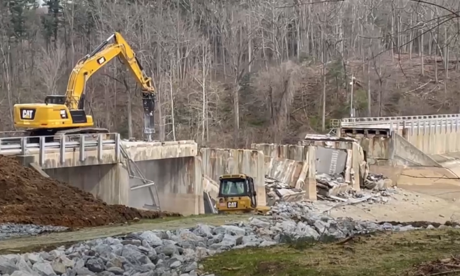 Video of heavy equipment demolishing a bridge.