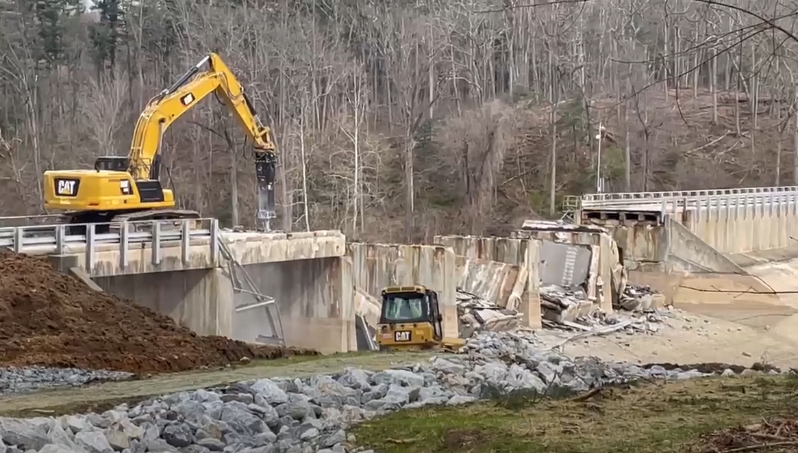 Video of heavy equipment demolishing a bridge.