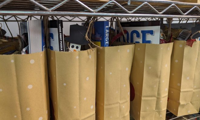 Brown bags are filled with donations for Cheer Bags for seniors.