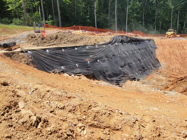 A large, temporary cofferdam to divert excess stream flow is being built around the construction site. A “soil nail wall” to stabilize a sizable excavation on the left side of the dam was just installed, and dewatering wells that will be used to control groundwater levels during construction are being drilled.