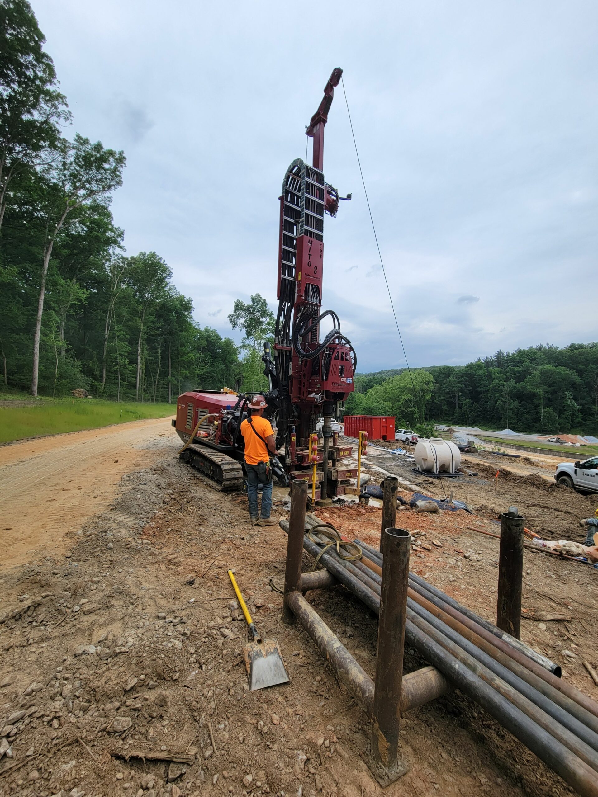 An operator is using a remote unit to control a Sonic drill unit to penetrate the very dense rock at Lake Williams to install a dewatering system around the construction zone.