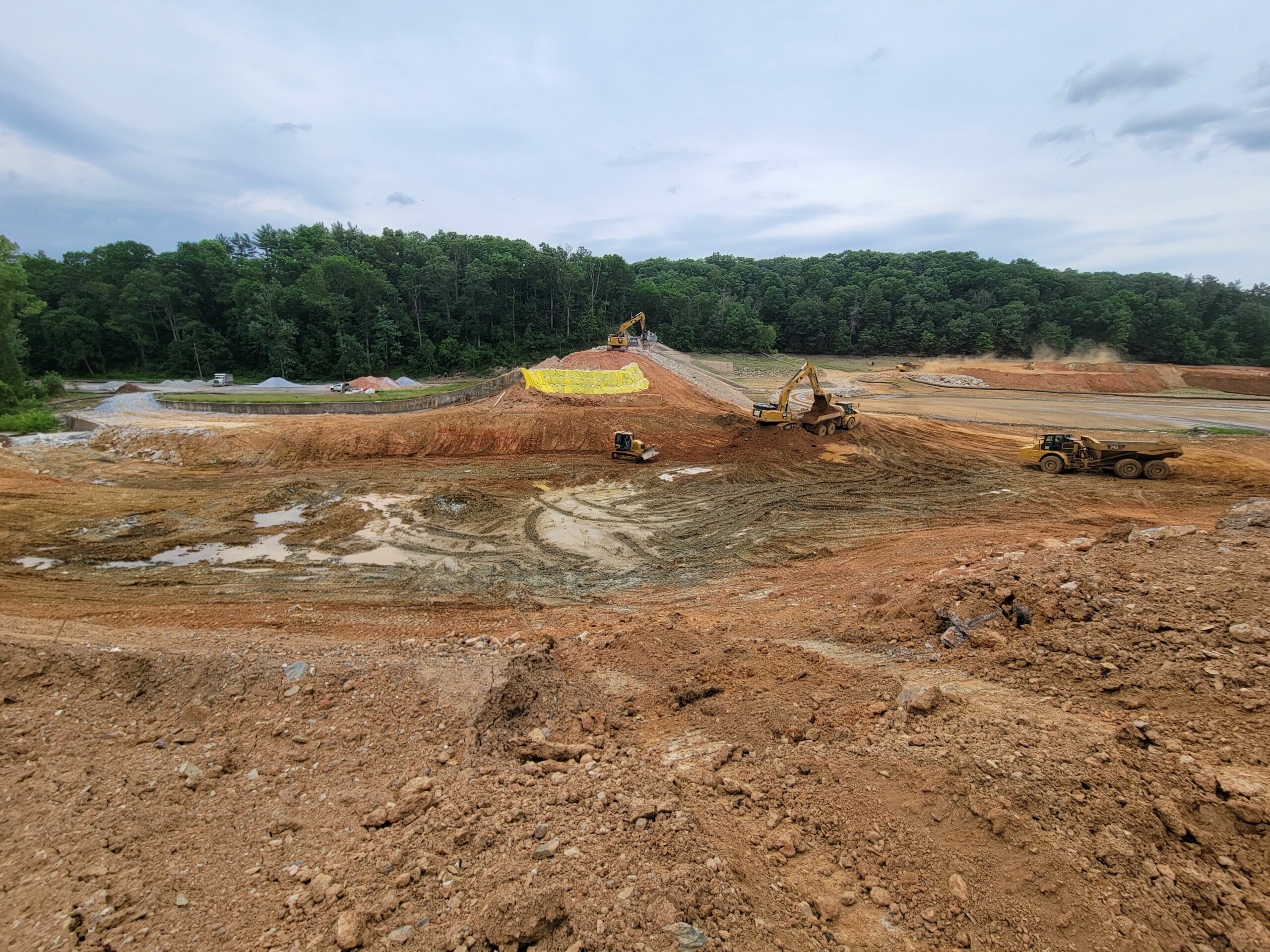 The spillway’s fill material has been mostly removed, exposing the top of weathered bedrock. Work continues on removing sections of Water Street over the top of the dam.