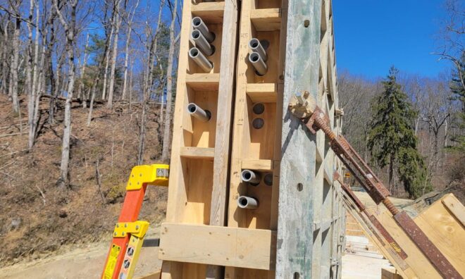 Electrical conduits being installed in the concrete wall.