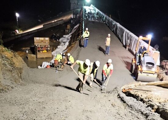 Workers constructing the bridge at night.