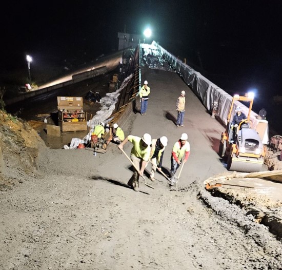 Workers constructing the bridge at night.