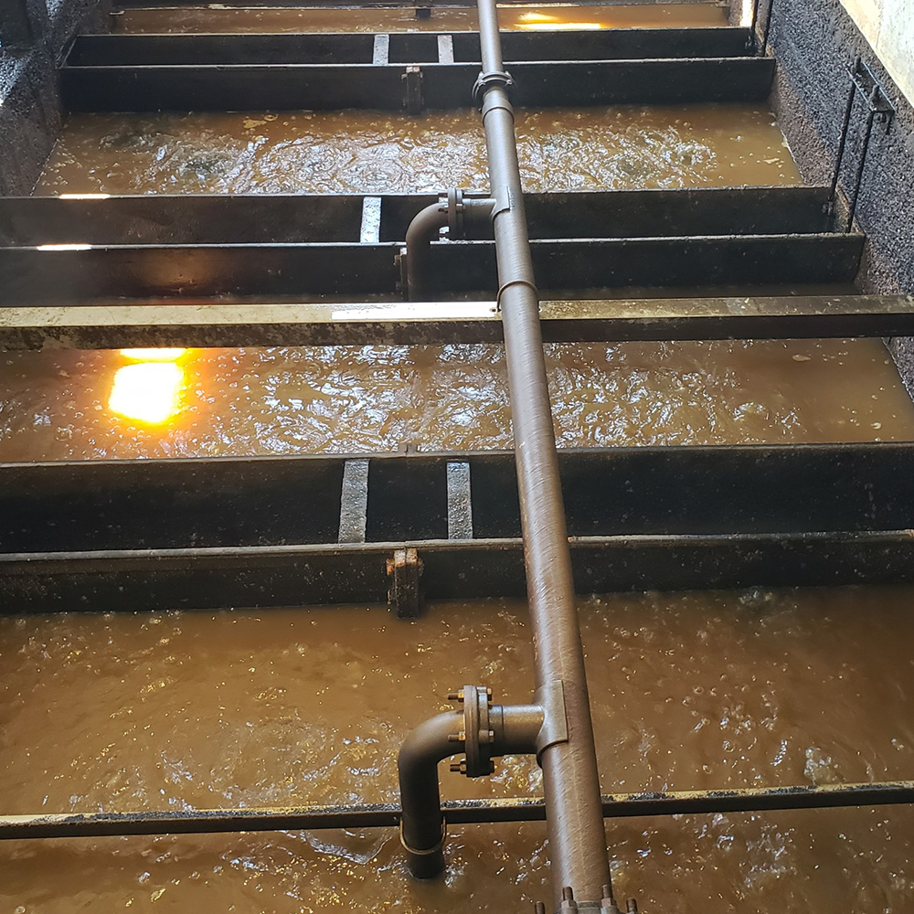 Close up shot of separate tanks of dirty water being treated and filtered.